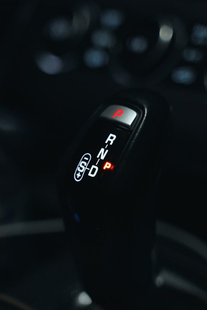 an-automatic-shift-knob-14633795 Detailed view of a cars automatic gear shift knob in a vehicle interior.